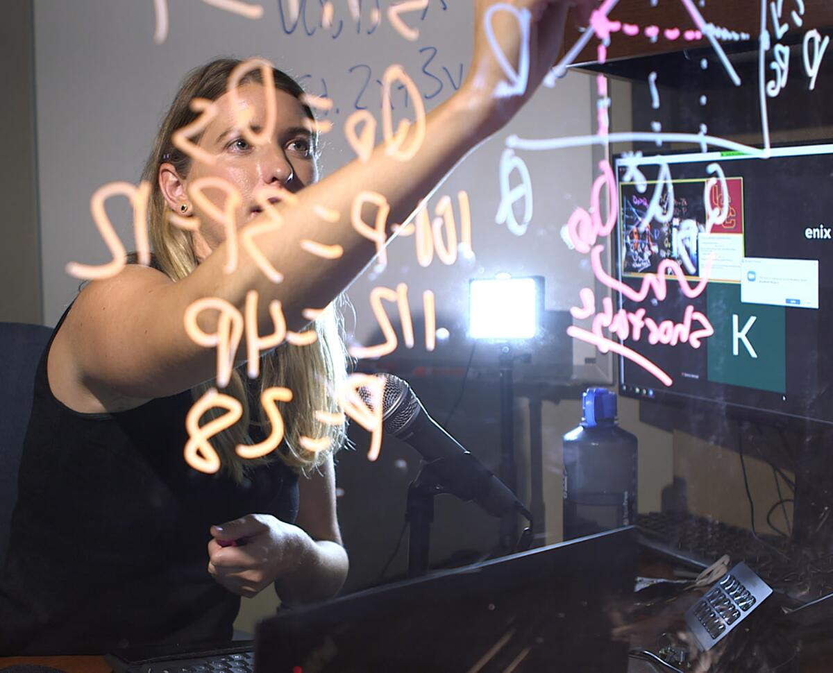 USC economics professor Emily Nix writes on a lightboard she built herself.