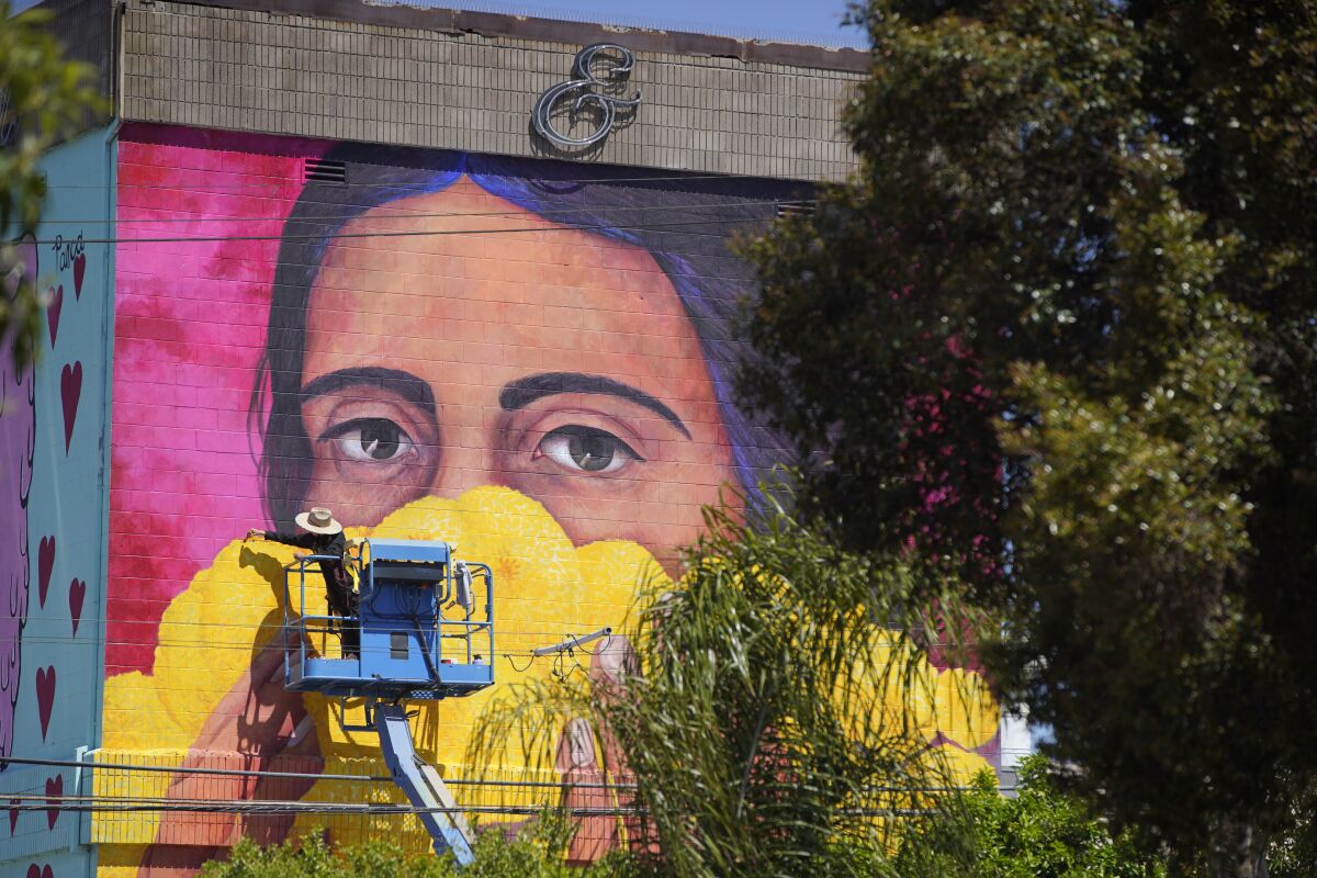 Local artist Tatiana Ortiz Rubio paints a 45-foot mural on the wall of Bread and Salt, titled Stop the Spread. 