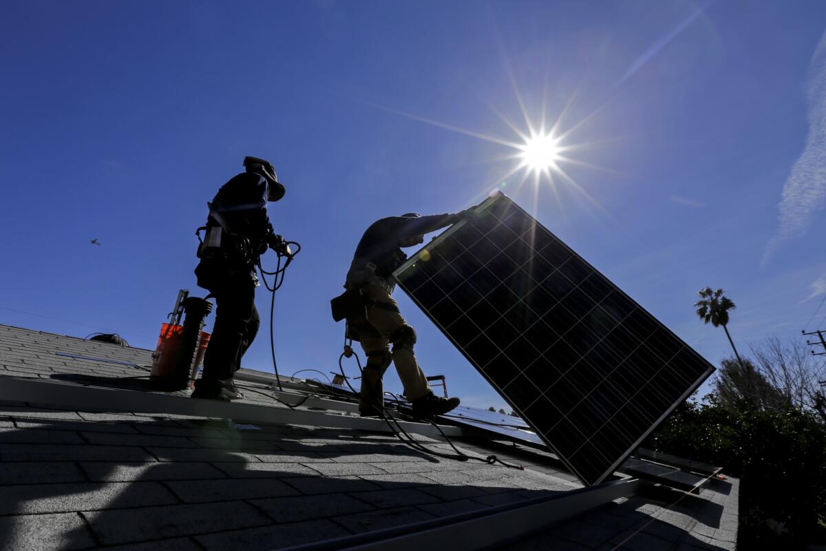 A crew from Sunrun home solar company installs a solar system on a Van Nuys house. Some in the industry fear that tariffs on foreign panels could increase costs and hurt sales and employment.