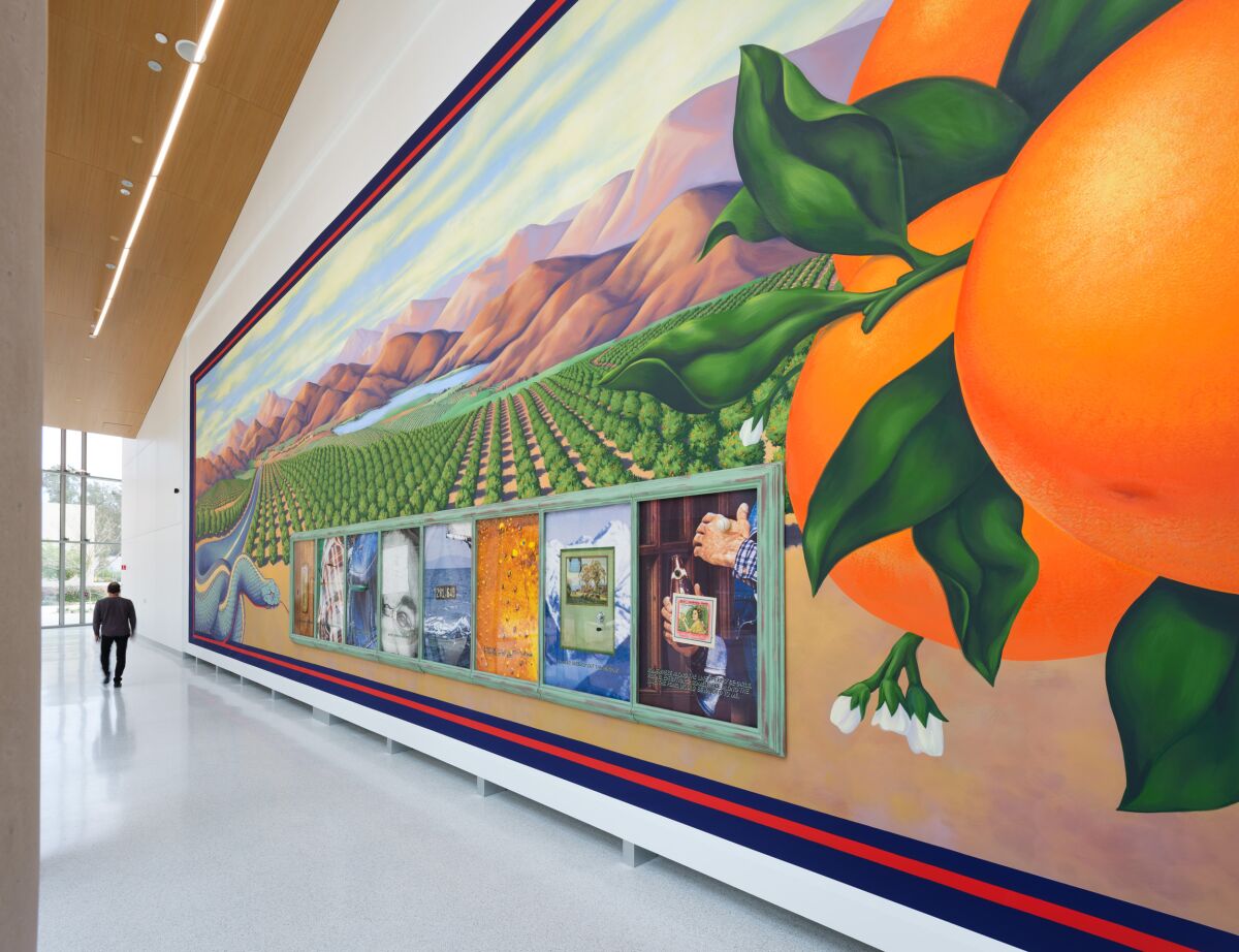 A large painting with trees, mountains, giant oranges and more.