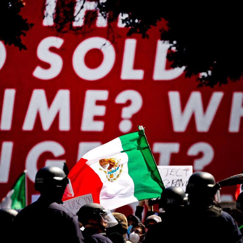 Law enforcement officers and other people, with some holding flags.