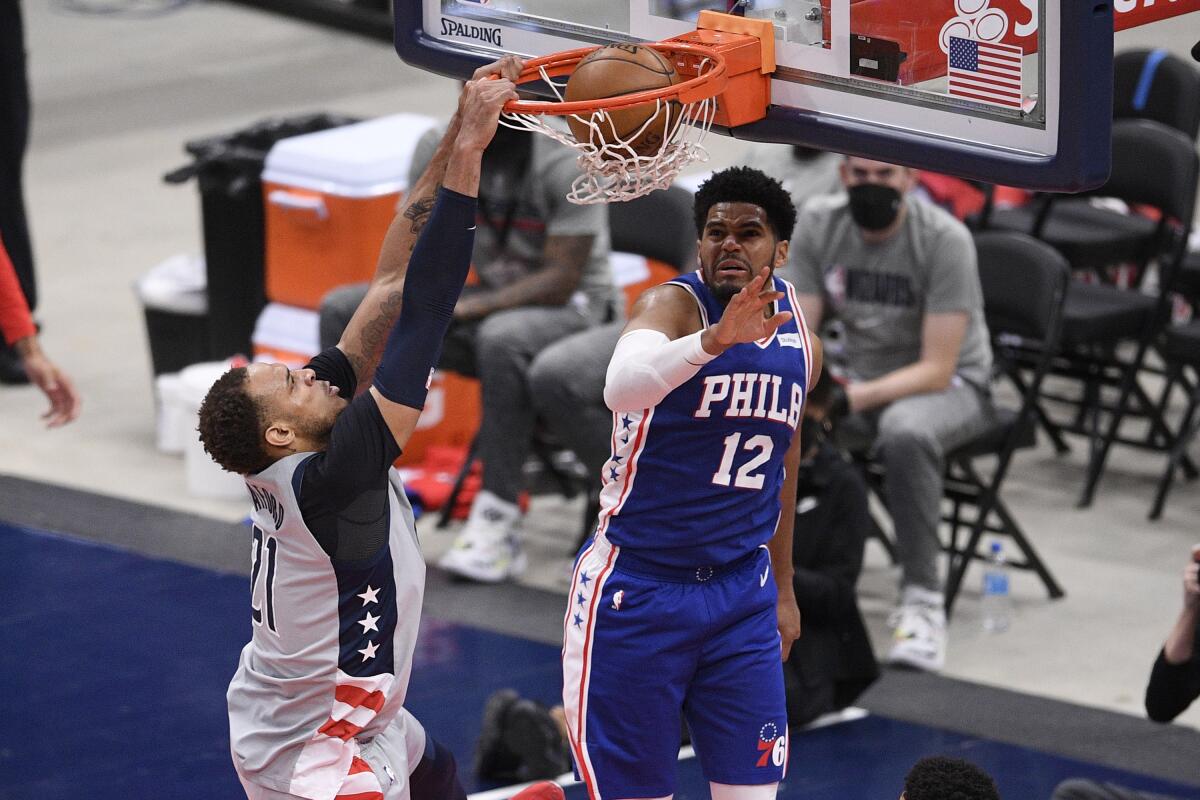 Washington Wizards center Daniel Gafford (21) dunks against Philadelphia 76ers forward Tobias Harris (12) during the second half of Game 4 in a first-round NBA basketball playoff series, Monday, May 31, 2021, in Washington. (AP Photo/Nick Wass)
