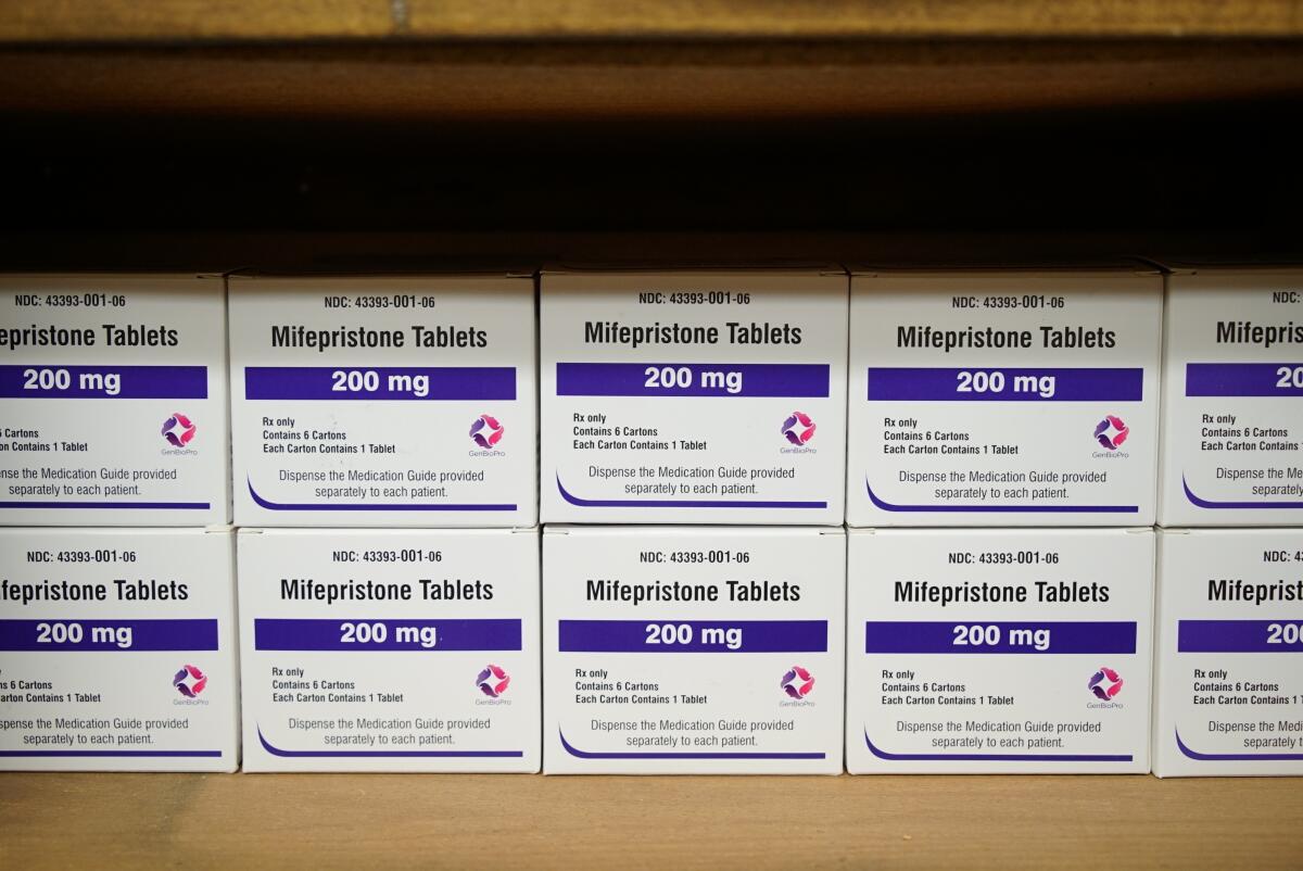 Rows of boxes labeled "mifepristone tablets" sitting on a shelf.