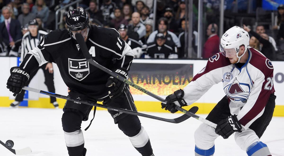 Kings center Anze Kopitar is hit by the stick of Avalanche center Nathan MacKinnon during a game on Oct. 18.