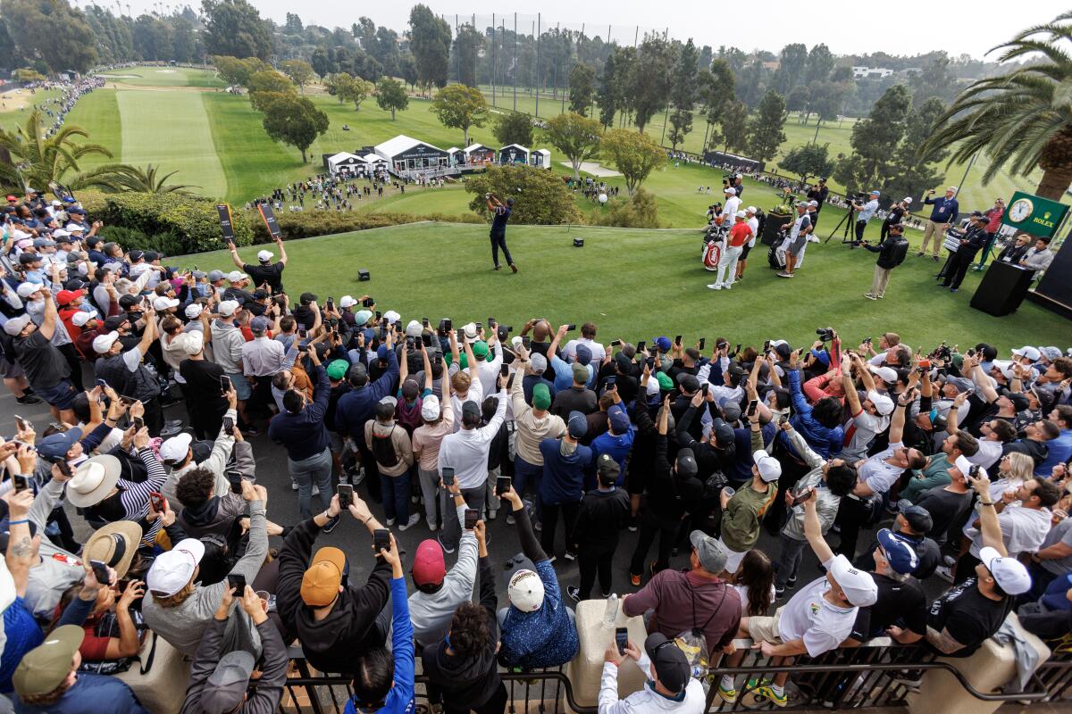 Fans watch Tiger Woods as hits off the first tee during the second round of the Genesis Invitational on Friday.