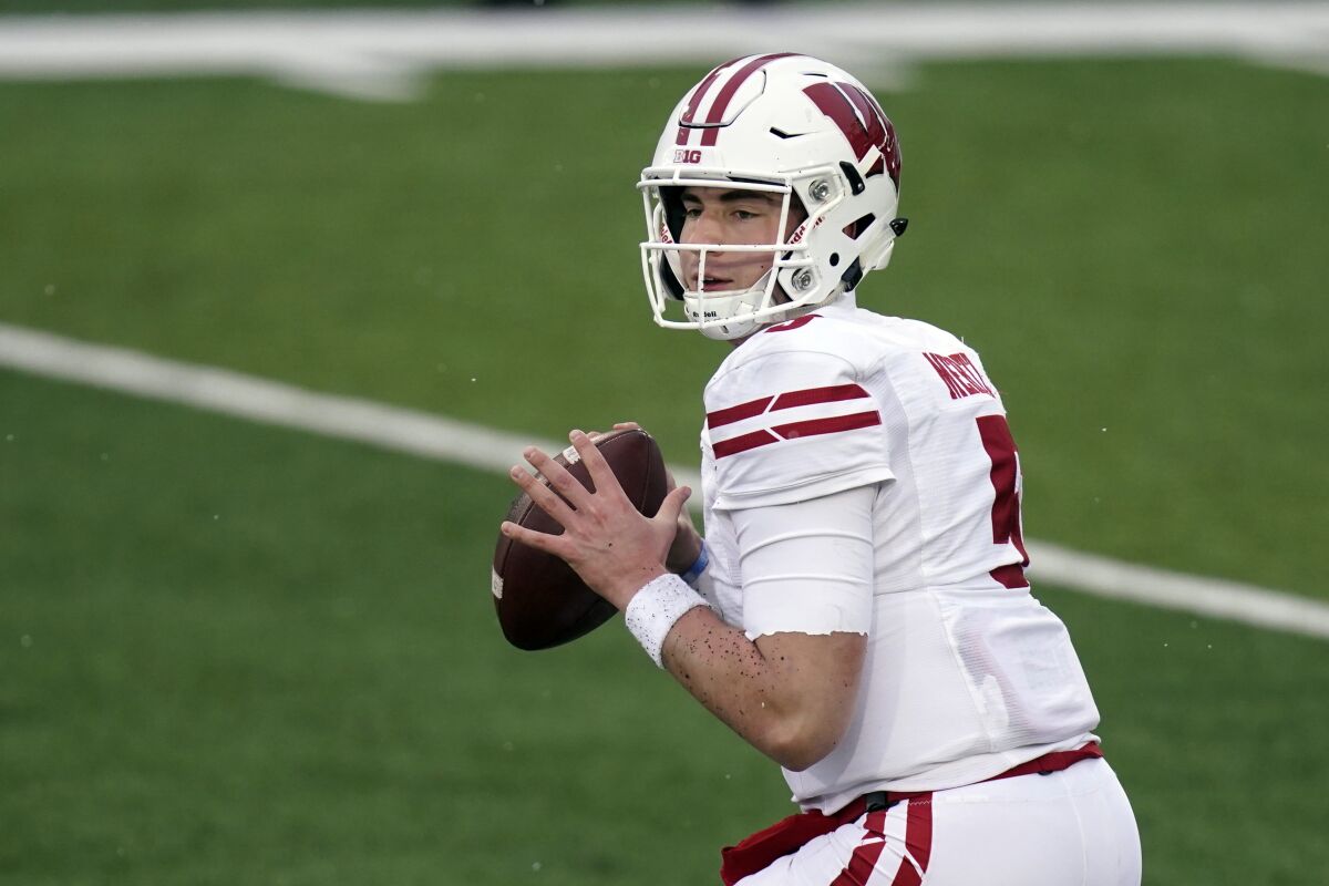 FILE - In this Dec. 12, 2020, file photo, Wisconsin quarterback Graham Mertz throws a pass during an NCAA college football game against Iowa in Iowa City, Iowa. Wisconsin faces Penn State on Saturday as they open their college football season.(AP Photo/Charlie Neibergall, File)
