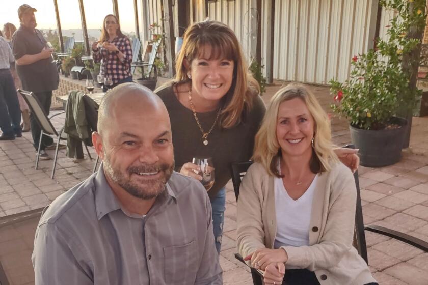 Tracey Wilson, center, joins Mike Herr and his wife, Brenda Herr, for a glass of wine at the Soiree Under the Stars event.