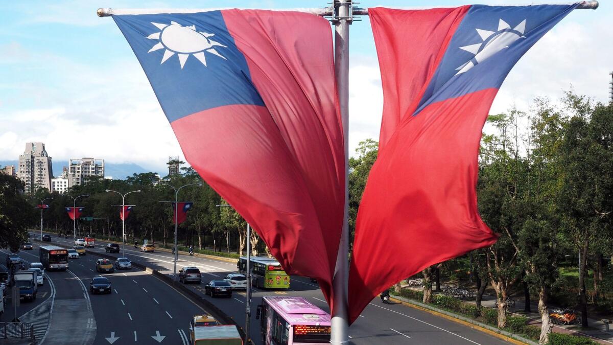 Traffic passes beneath Taiwan's national flags on a road in Taipei, Taiwan on Oct. 17, 2016.