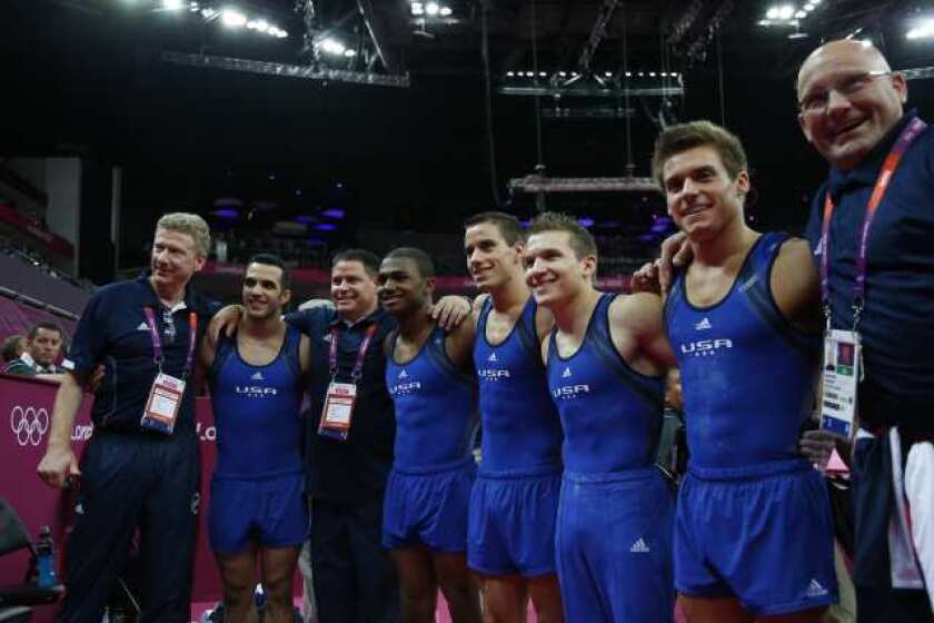U.S. gymnasts and team officials pose during qualifications in London. The gymnasts, from left in uniform, include Danell Leyva, John Orozco, Jacob Dalton, Jonathan Horton and Samuel Mikulak.