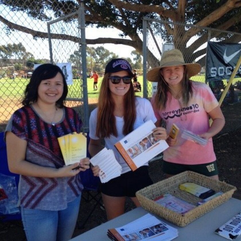 Michelle Temby handed out materials at the 2014 Surf Cup with volunteers and soccer teams. Courtesy photo