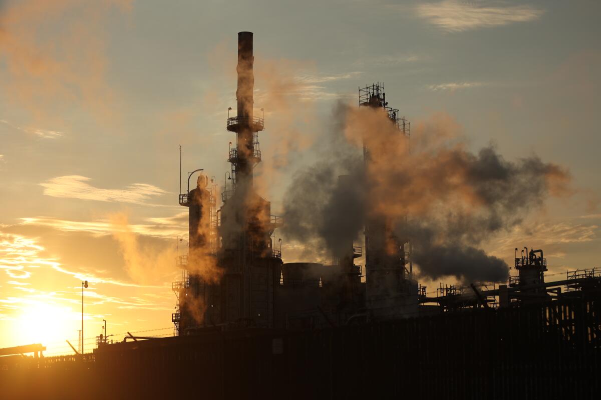 Smoke puffs through the air at a refinery