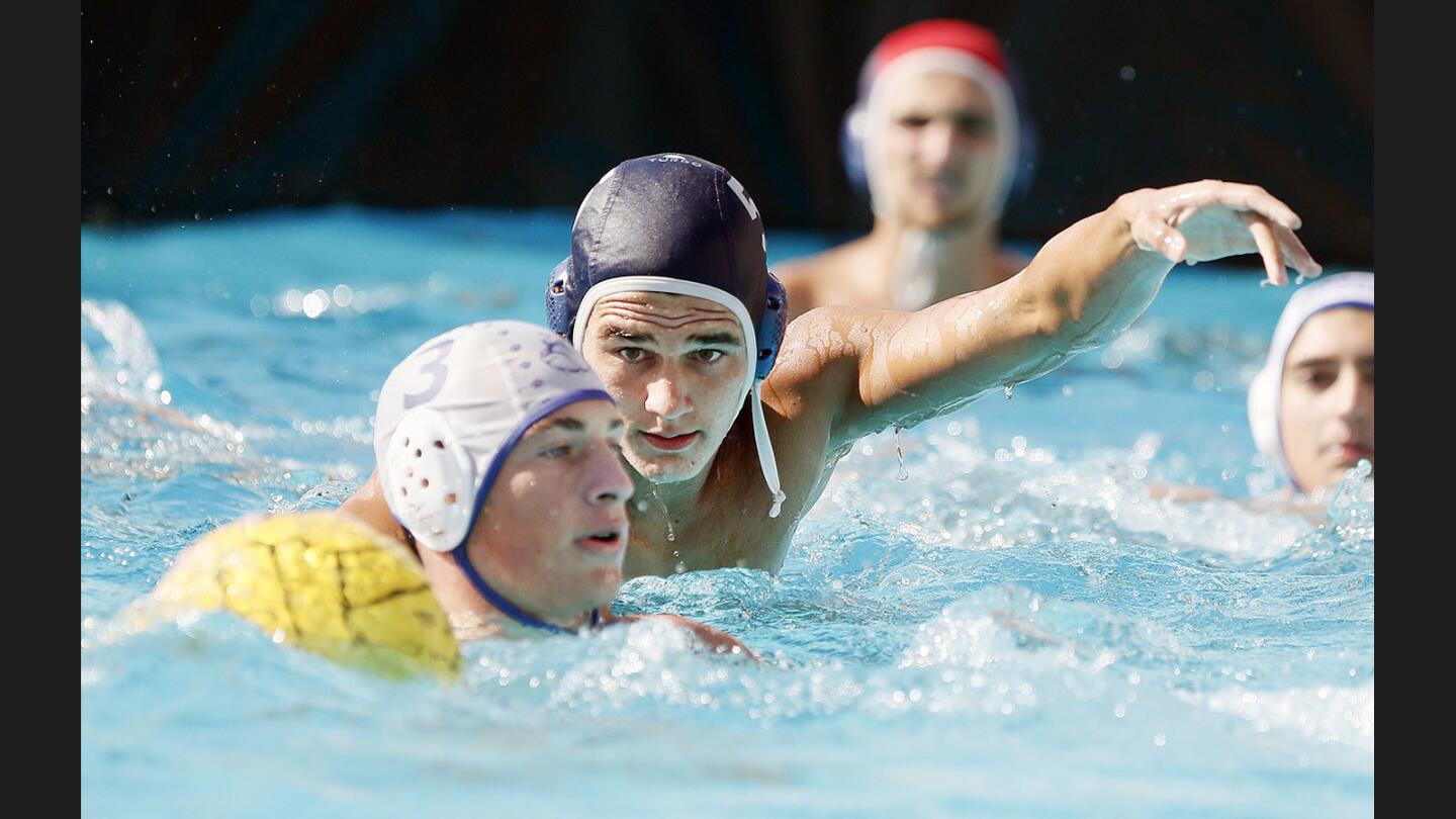 Crescenta Valley's Bodoe Wyss reaches over Burbank's Brandon Wilson in defense in a Pacific League boys' water polo match at Crescenta Valley High School on Tuesday, September 26, 2017.