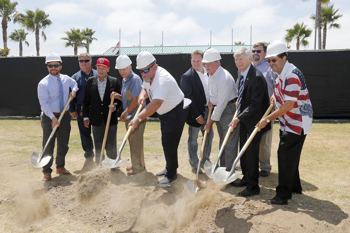 Emcee Ed Arnold, third from right, and project team members scoop dirt during a groundbreaking ceremony Thursday for the relocation of a Vietnam War-era A-4 Skyhawk jet to Heroes Hall at the Orange County fairgrounds in Costa Mesa. The aircraft will be moved from the Santa Ana Civic Center this fall, with a rededication ceremony expected around Veterans Day in November.