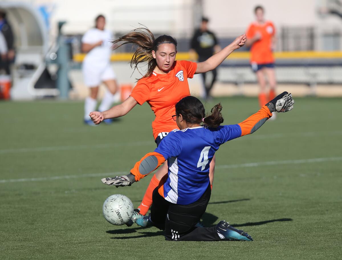 Maggie O'Callaghan of Pacifica Christian Orange County takes a shot as St. Mary's goalkeeper Erika Carcamo (4) slides in for the block during a CIF Southern Section Division 6 wild-card round playoff match on Tuesday at Vanguard University.