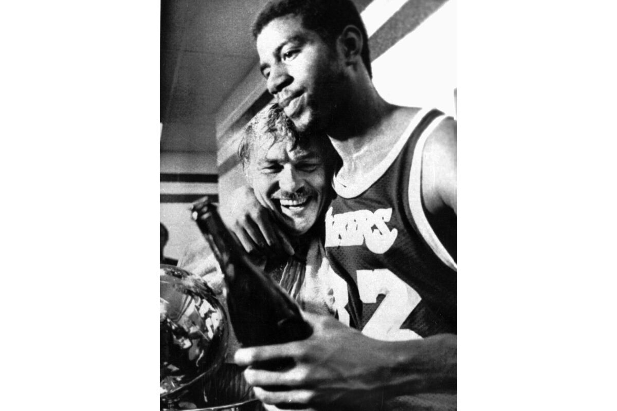  Los Angeles Lakers Earvin "Magic" Johnson hugs team owner Jerry Buss in the locker room