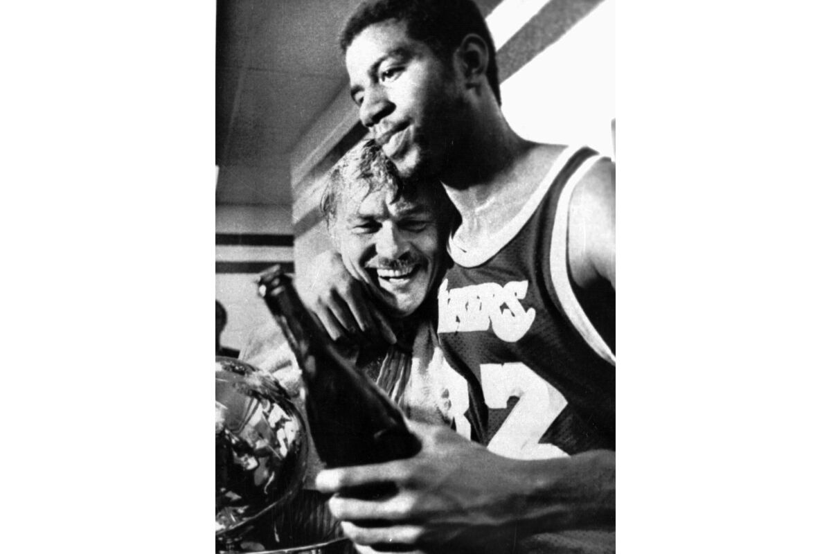 Los Angeles Lakers Earvin "Magic" Johnson hugs team owner Jerry Buss in the locker room
