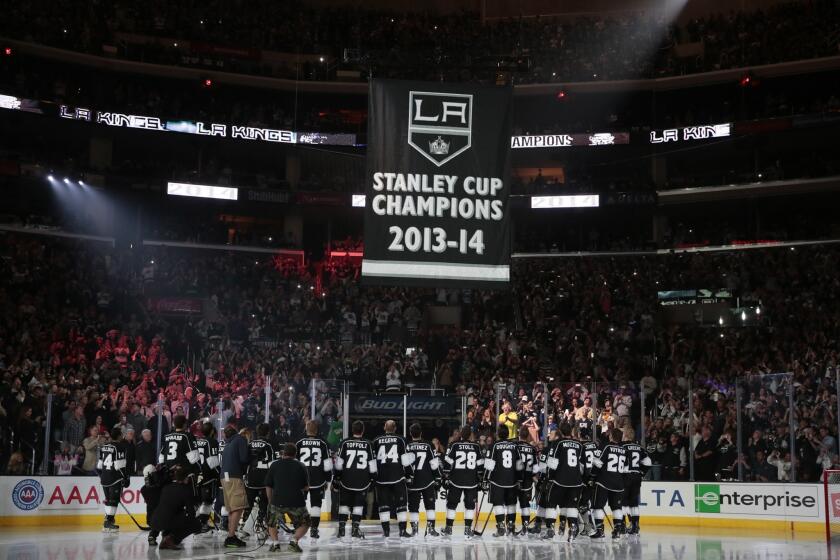 A banner honoring the Kings' 2013-14 Stanley Cup championship is lifted to the Staples Center rafters prior to the team's season 2014-15 season opener against the San Jose Sharks on Wednesday.