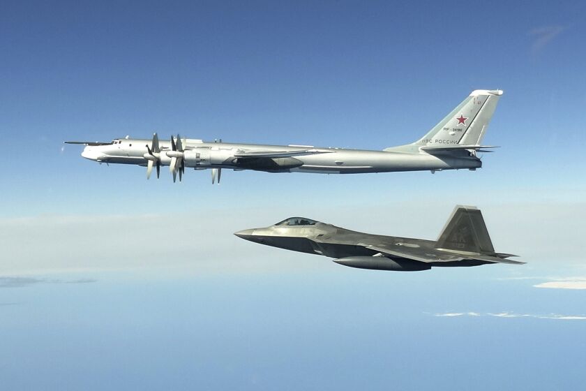 CORRECTS SECOND AND THIRD SENTENCES - In this image taken Tuesday, June 16, 2020, and released by the North American Aerospace Defense Command, a Russian Tu-95 bomber, top, is intercepted by a U.S. F-22 Raptor fighter off the coast of Alaska. Russian nuclear-capable strategic bombers have flown near Alaska on a mission demonstrating the military's long-range strike capability. The Russian Defense Ministry said that four Tu-95 bombers have flown over the Sea of Okhotsk, the Bering Sea, the Chukchi Sea and the Northern Pacific during an 11-hour mission. The ministry said the bombers were escorted by U.S. F-22 fighters during part of their patrol. (North American Aerospace Defense Command via AP)