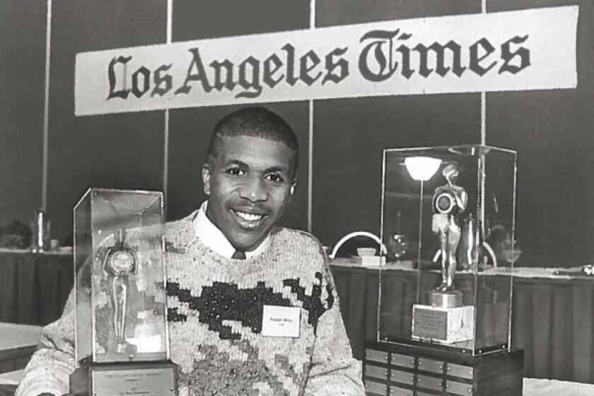 Crespi running back Russell White holding the Glen Davis trophy.