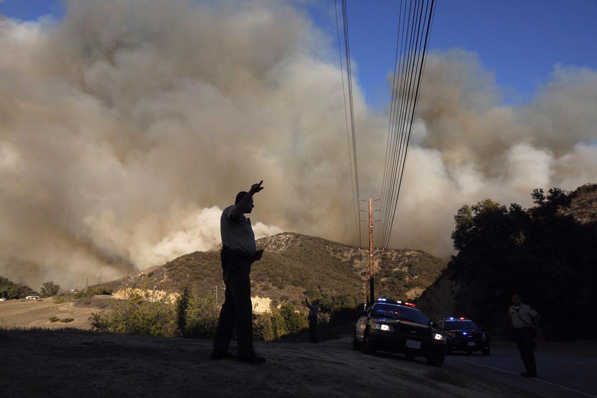 Sheriff's deputies block off Mulholland Drive in Malibu as the Woolsey fire continues its path towards the coast.