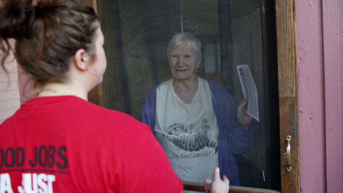 Helen Kent, 82, listens to Working America canvasser Jaclyn McCann, as she canvasses for Democratic gubernatorial candidate Gretchen Whitmer.