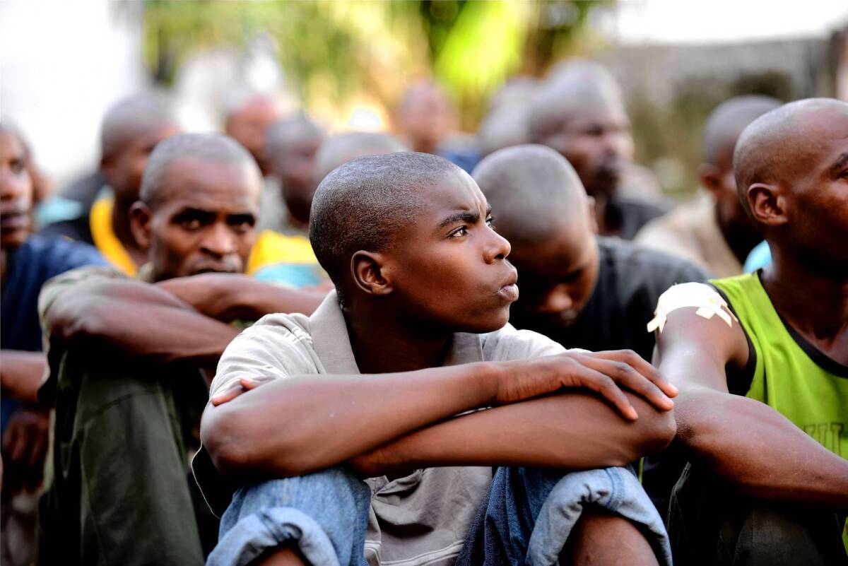 A youth identified as a 16-year-old corporal in the Rwandan armed forces sits with other prisoners in Kinshasha, capital of the Democratic Republic of Congo. The government accuses Rwanda of supporting rebels fighting in eastern Congo.