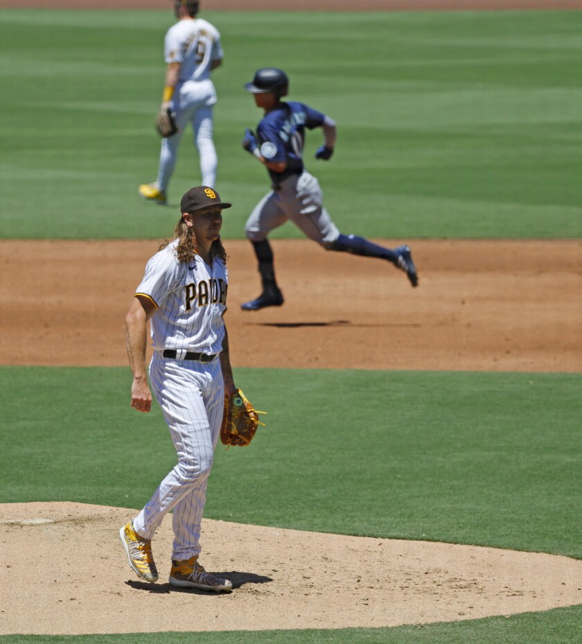 Padres pitcher Mike Clevinger waits for a new ball as the Mariners' Sam Haggerty rounds the bases 