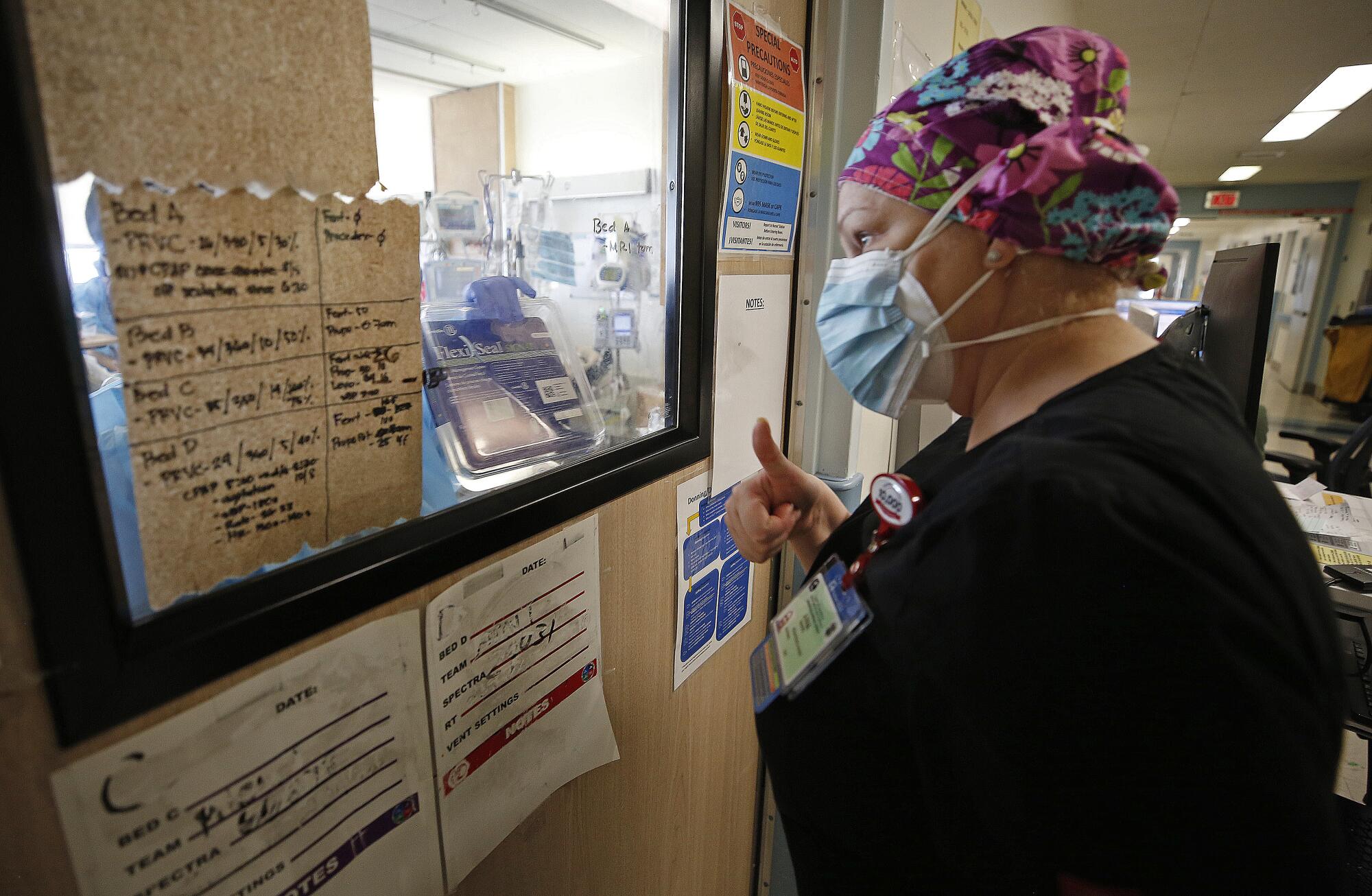 Registered nurse Anna Hansel gives a thumbs-up sign to a colleague.