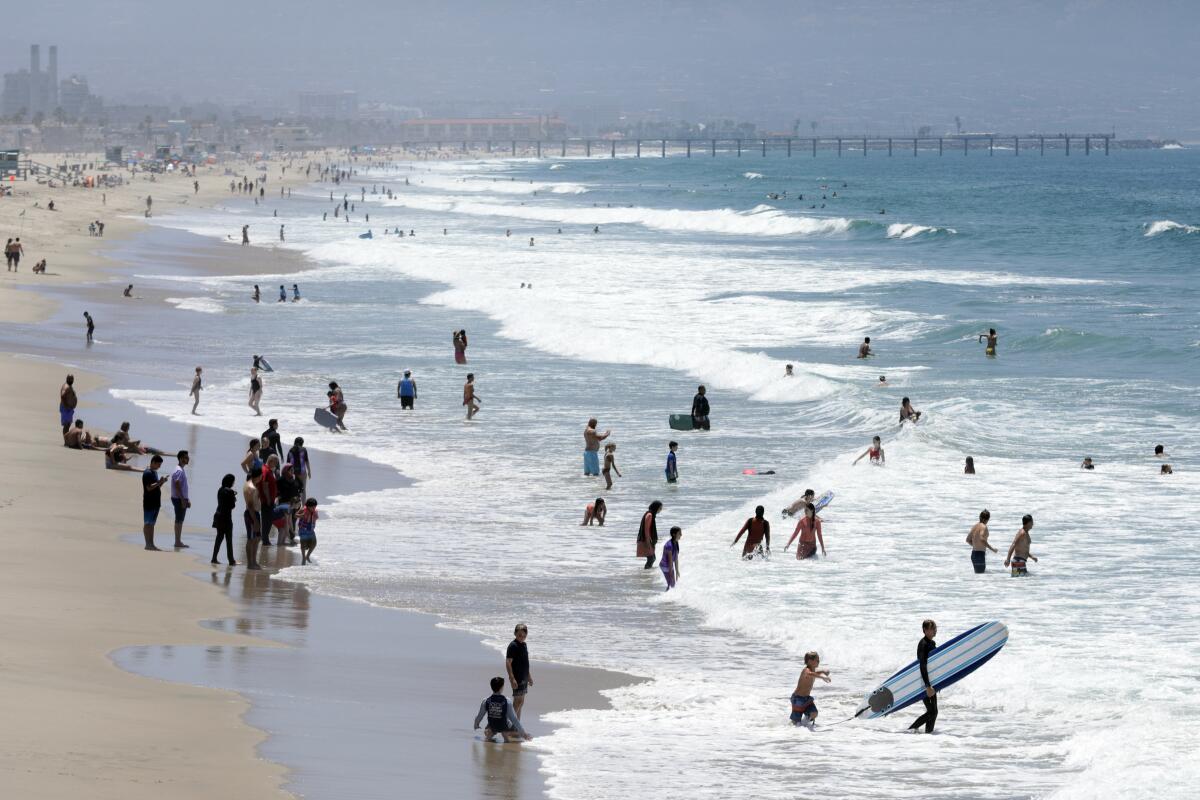 A light crowd enjoys the sand and surf at Manhattan Beach on July 6, 2020, following the three-day Fourth of July weekend. 