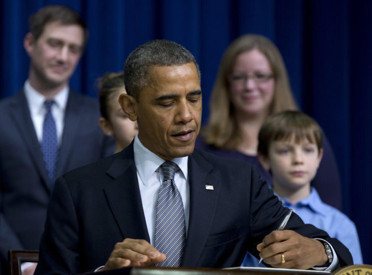 President Obama signs executive orders outlining proposals to reduce gun violence in the South Court Auditorium at the White House in Washington.