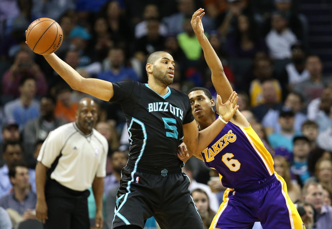 Hornets forward Nicolas Batum keeps the ball away from Lakers guard Jordan Clarkson.