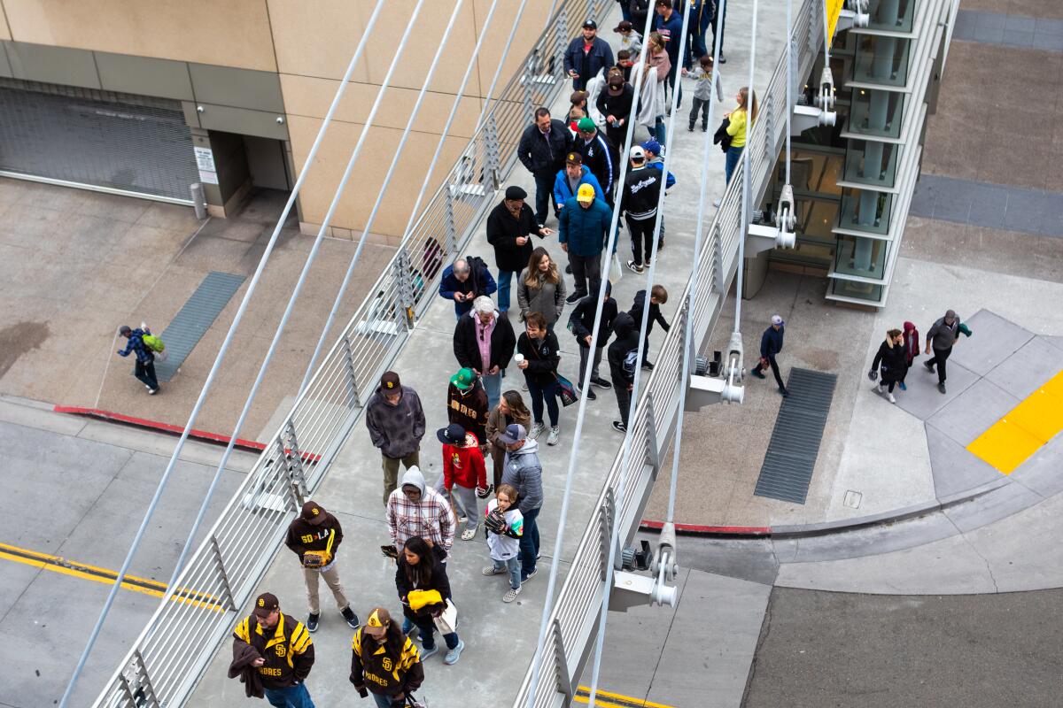 People wait on a skybridge to enter Petco Park in downtown San Diego.