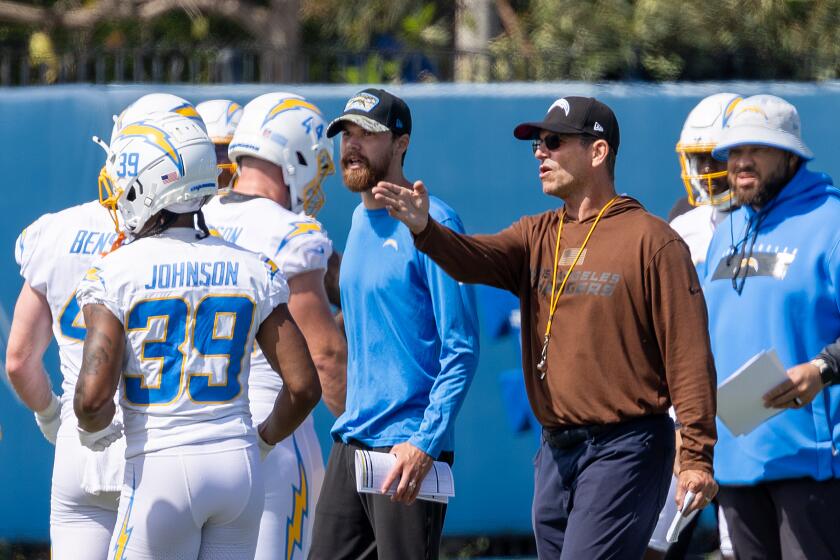Coach Jim Harbaugh (brown hoodie) is pointing the Chargers in a new direction.