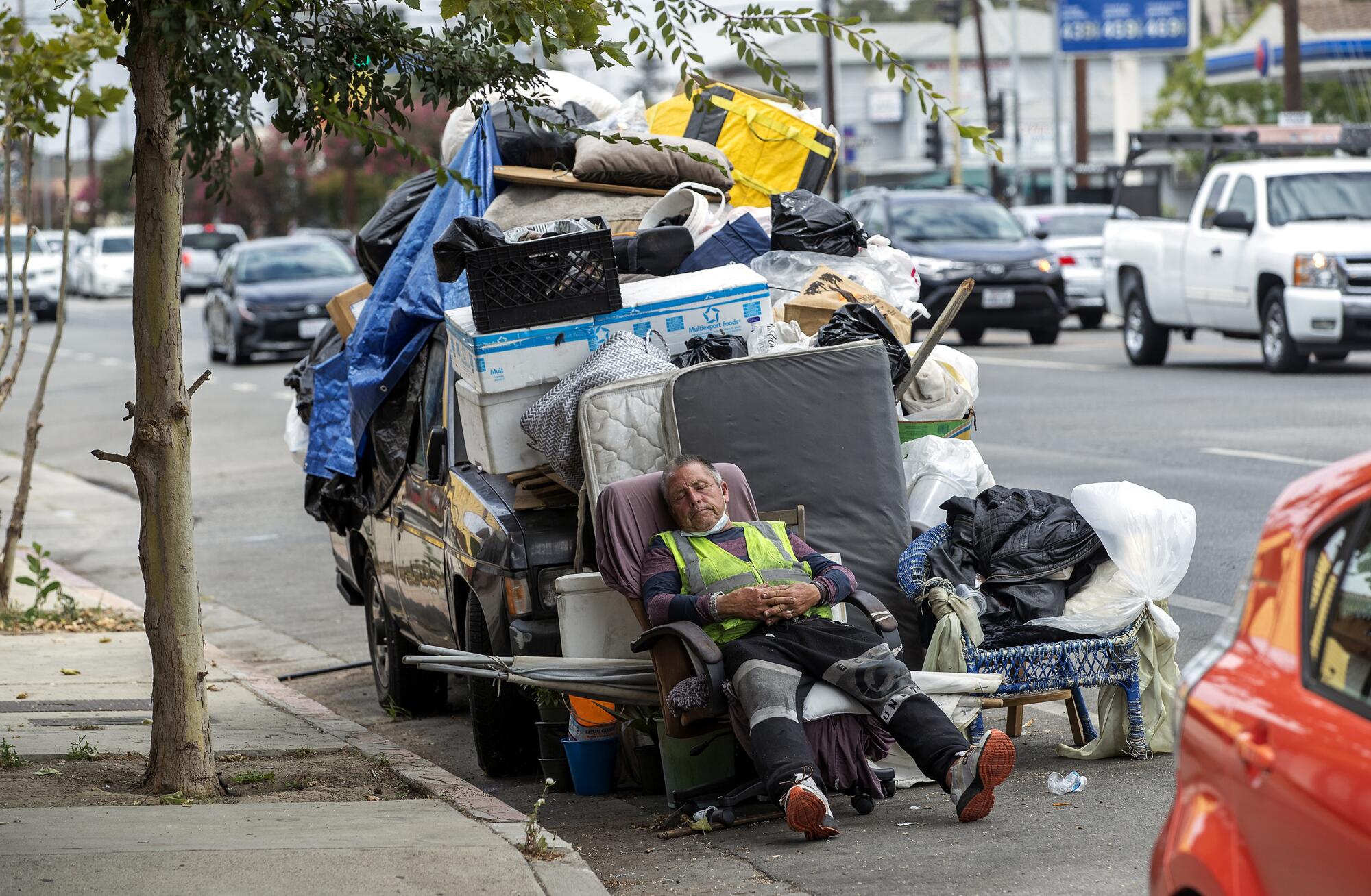 Ricardo De Alejandro, who said that he has been homeless for the past 3 years, relaxes in the shade in North Hollywood.