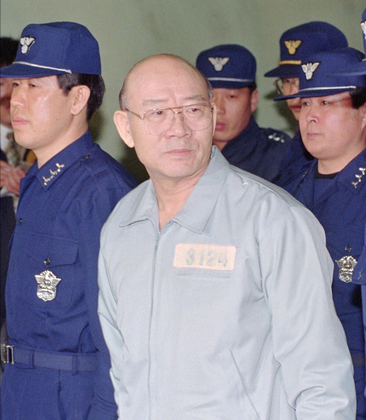 Former South Korean President Chun Doo-hwan, in a prison uniform, enters the Seoul Court House in 1996 for his first trial on charges stemming from a 1980 military coup and allegations of accepting secret funds.