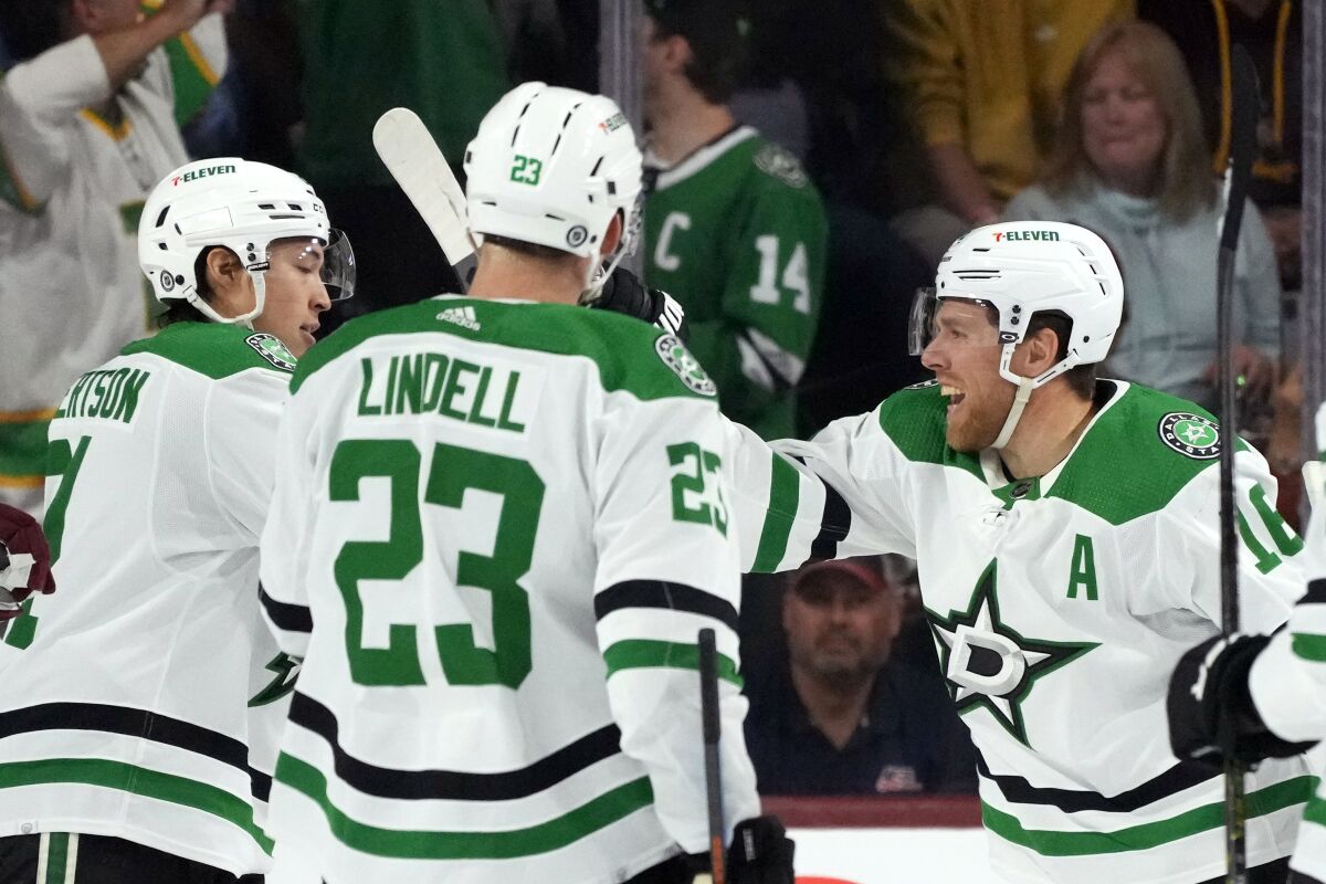 Dallas Stars center Joe Pavelski, right, smiles as he celebrates his goal against the Arizona Coyotes with defenseman Esa Lindell (23) and left wing Jason Robertson, left, during the first period of an NHL hockey game Friday, March 31, 2023, in Tempe, Ariz. (AP Photo/Ross D. Franklin)