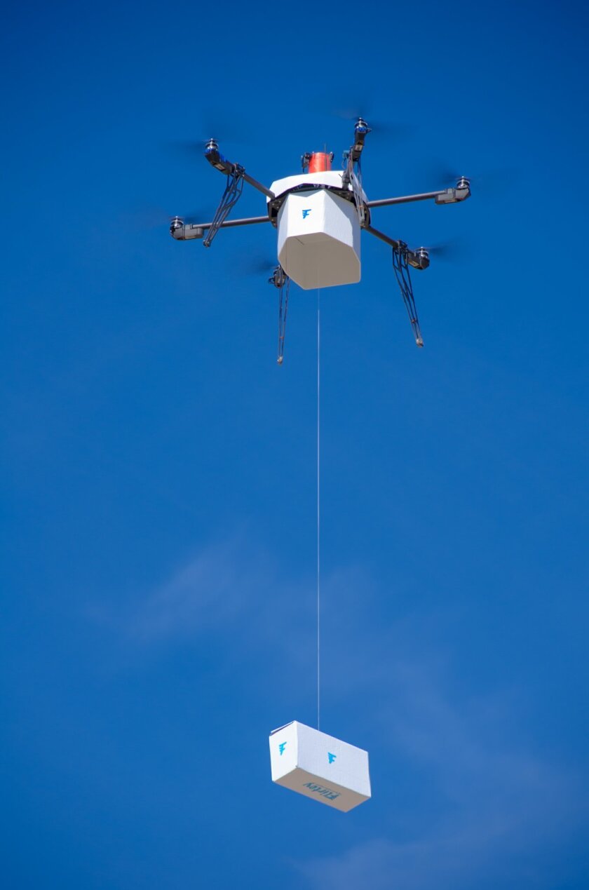 In this Friday, March 25, 2016, photo provided by Flirtey, an independent drone delivery company, shows the first fully autonomous, FAA-approved urban drone delivery, a box with bottled water, emergency food and a first aid kit in a residential setting without the help of a human to manually steer it in Hawthorne, Nev. Flirtey CEO Matt Sweeney announced Friday the six-rotor drone flew itself about one-half mile and lowered the package outside a vacant residence in Hawthorne, about 140 miles southeast of Reno. (Flirtey via AP)