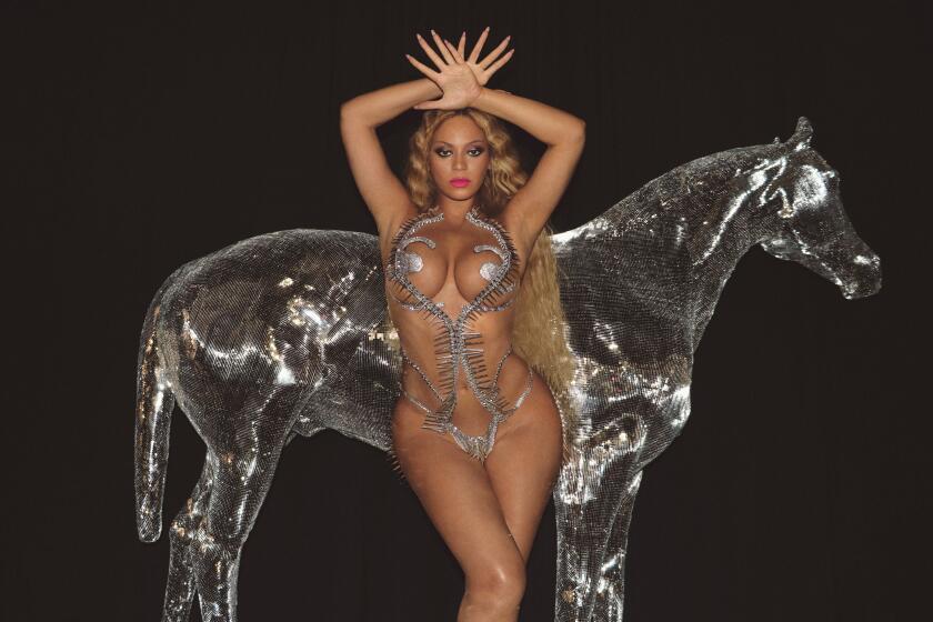 Beyoncé strikes a pose in a silver outfit with her hands over her head in front of a translucent silver horse