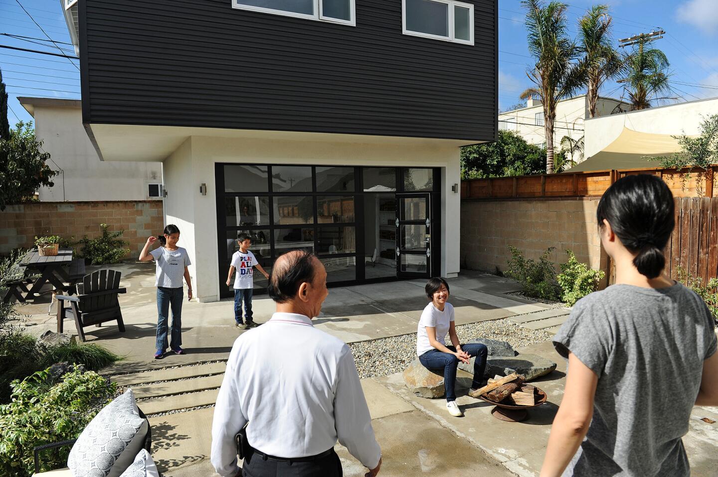 Architect Yuwen Peng, seated, outside the modern family compound she created to suit her multi-generation family in Venice including, from left, her niece, nephew, father and sister.