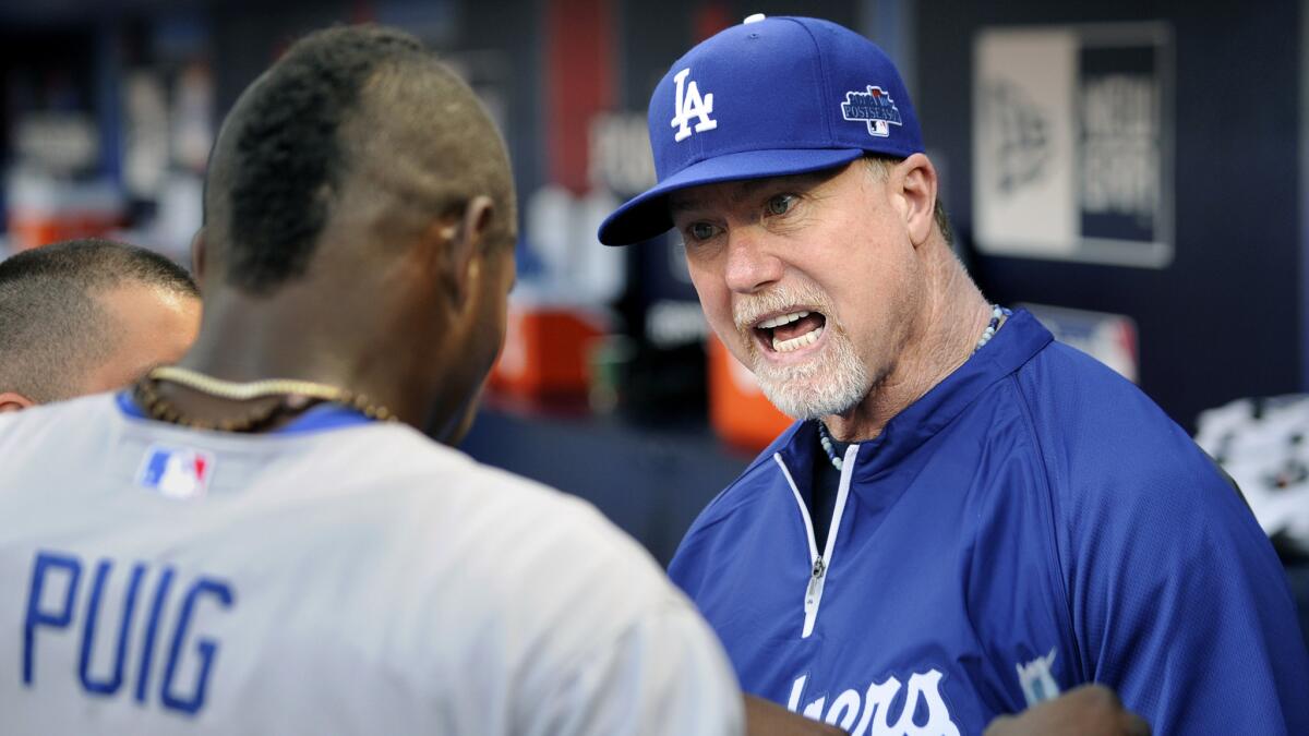 Dodgers batting coach Mark McGwire, right, speaks with Dodgers outfielder Yasiel Puig during the 2013 National League division series against the Atlanta Braves.