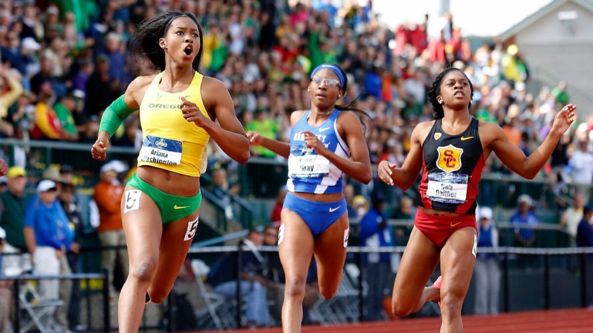 Oregon's Ariana Washington, left, looks to the video board after winning the women's 100-meter dash in front of Kentucky's Kianna Gray, center, and USC's Tynia Gaither, right, at the NCAA Outdoor Track and Field Championships.
