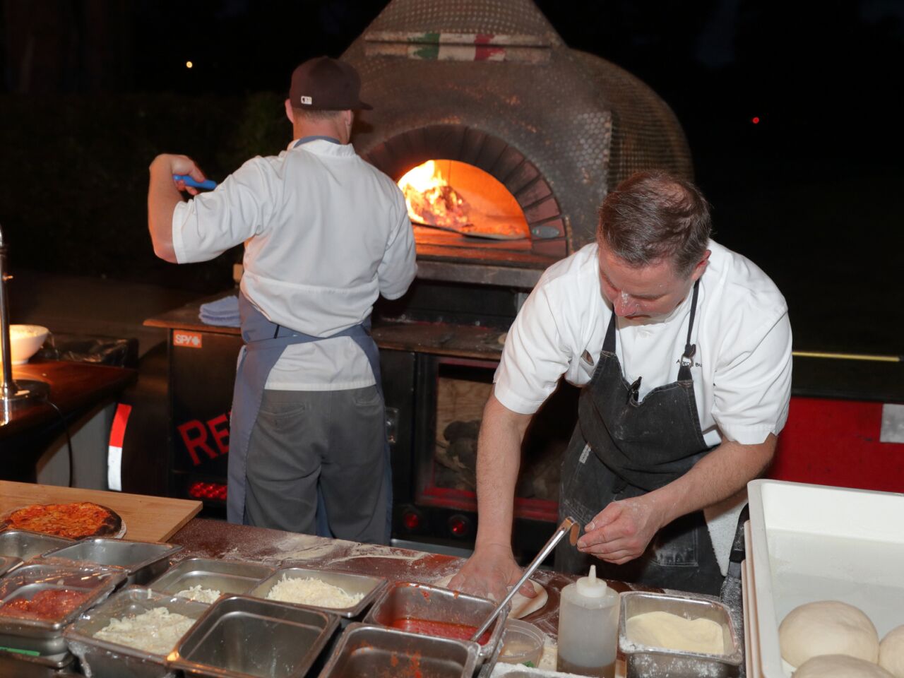 Josh Heinz and chef Aaron Burns man the outdoor pizza oven