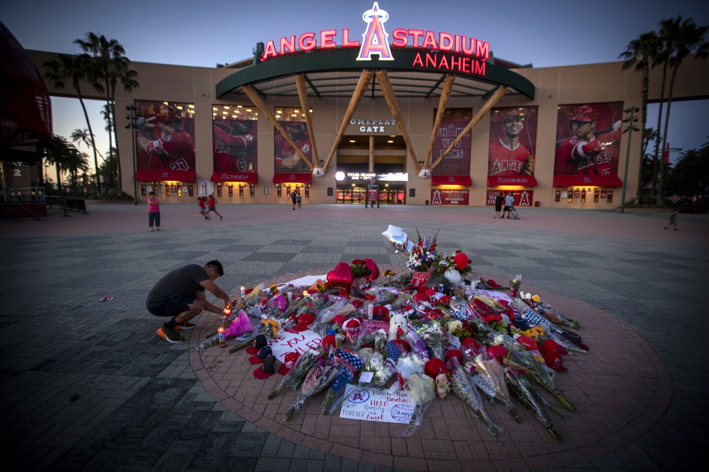 An Angels fan pays his respects by lighting candles at a growing memorial at Angel Stadium.