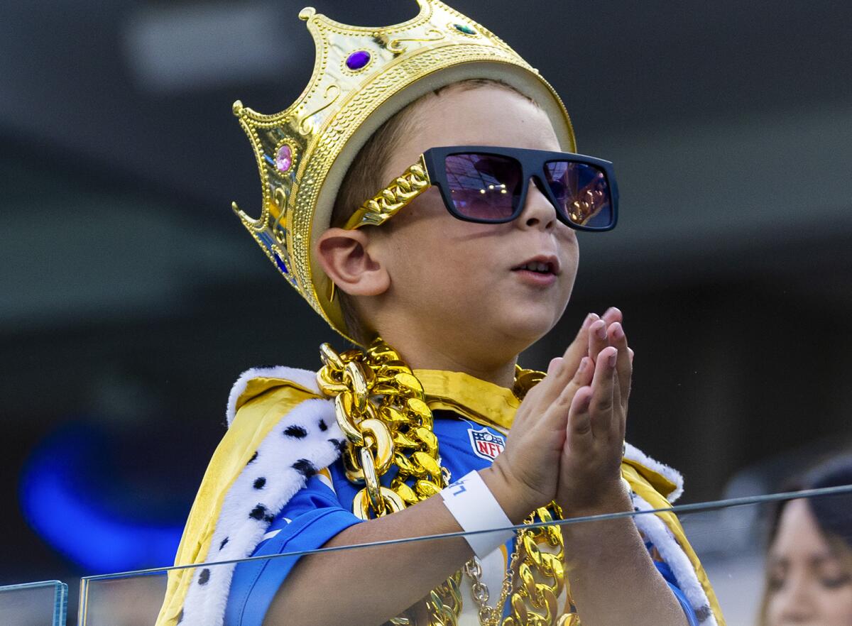 Chargers fan Aidan Blumberg, 6, seems to be praying during game against the Cowboys.