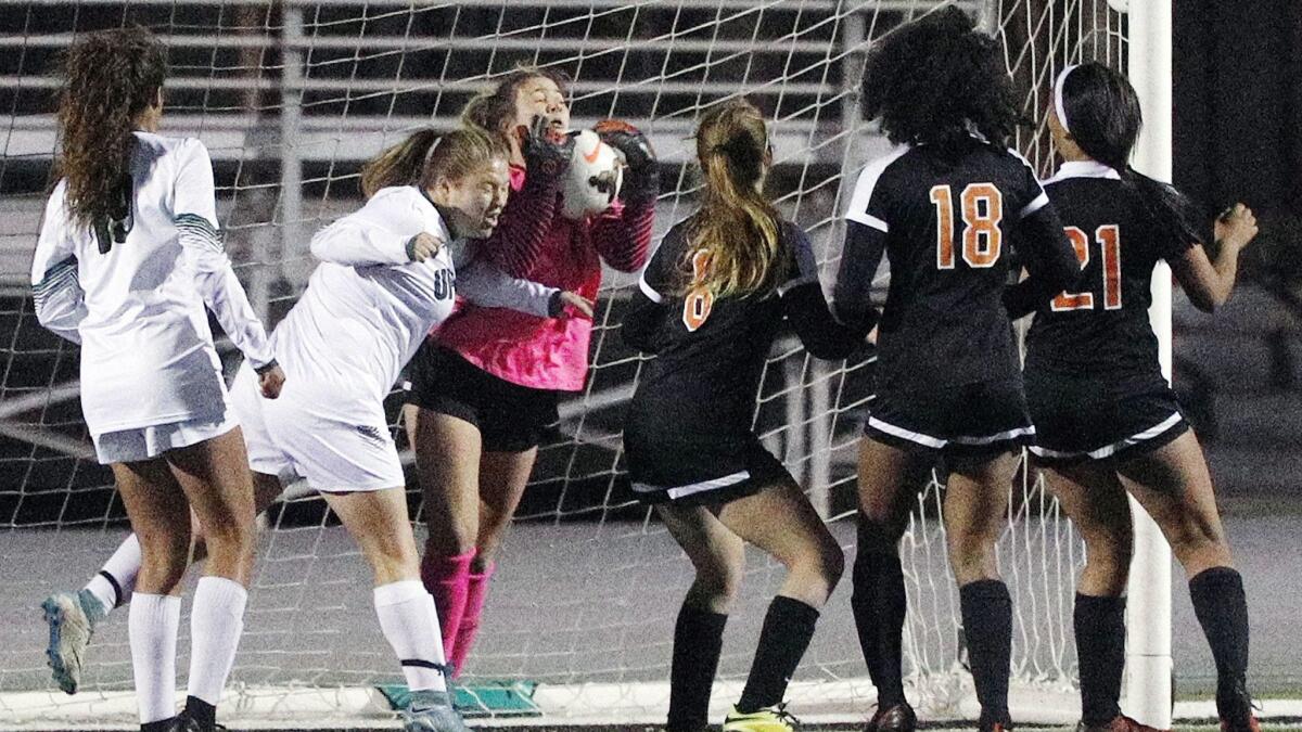 Huntington Beach High goalkeeper Chloe Romney grabs the ball in a crowd during the second round of the CIF Southern Section Division 1 girls' soccer playoffs on Tuesday.