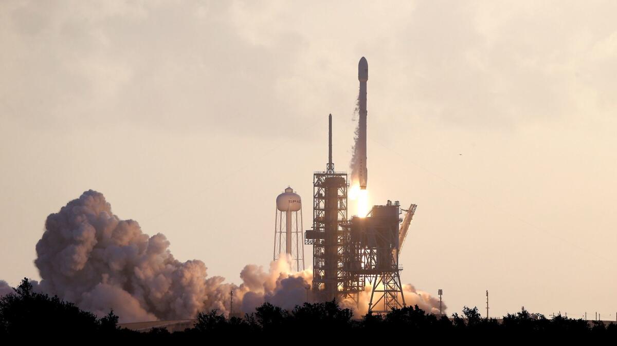 A Falcon 9 SpaceX rocket carrying a classified satellite for the National Reconnaissance Office lifts off at Kennedy Space Center in Florida.