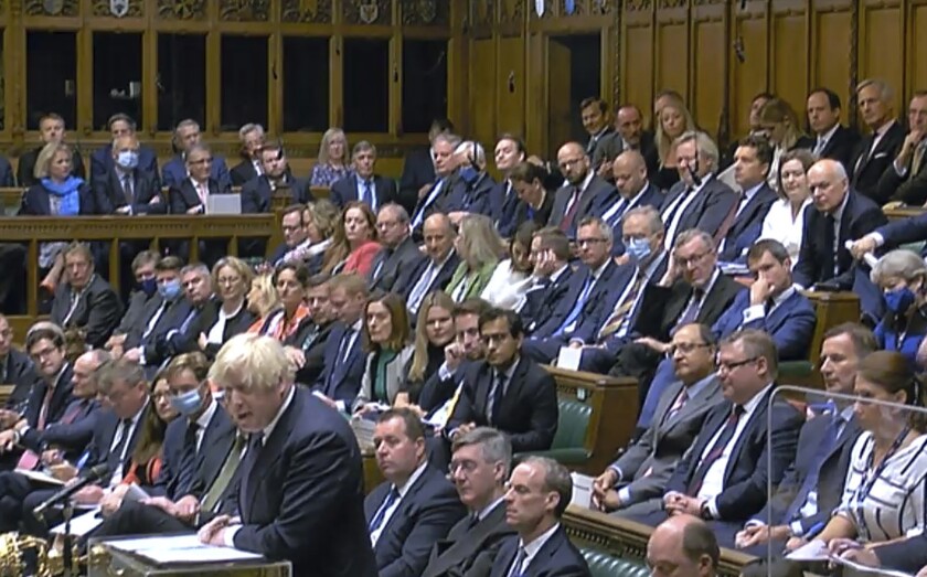 Britain's Prime Minister Boris Johnson speaks during the debate on the situation in Afghanistan inside parliament in London, as lawmakers attend an emergency sitting three days after the Afghanistan capital Kabul fell to the Taliban. Nearly all ruling Conservative Party lawmakers were not wearing face masks during the debate Wednesday, while opposition Labour Party lawmakers sat in parliament nearly all wearing face masks. (House of Commons via AP)