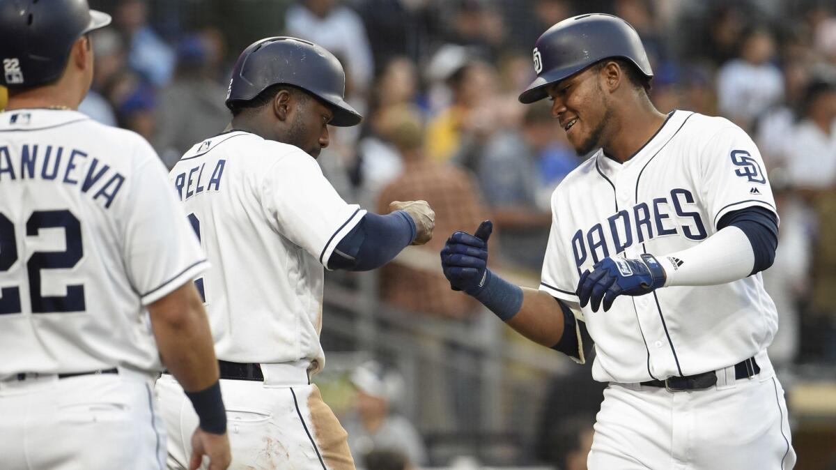 The Padres' Franchy Cordero, right, is congratulated by Jose Pirela as Christian Villanueva looks on after Cordero hit a three-run home run during the fourth inning of a baseball game against the New York Mets at Petco Park on April 28, 2018 in San Diego, California.