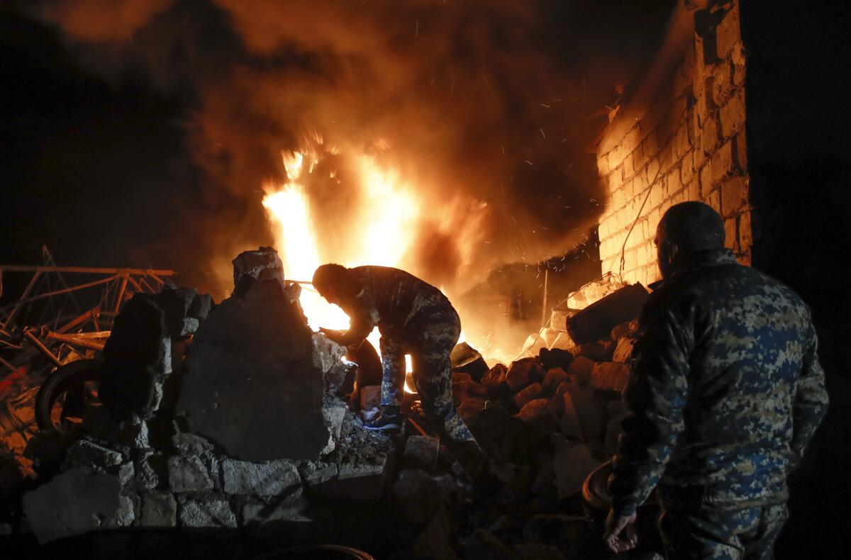 Tires are removed from an auto repair shop that was hit by shelling in the separatist region of Nagorno-Karabakh on Friday.