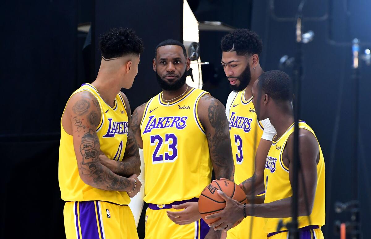 LeBron James and his Lakers teammates (left to right) Kyle Kuzuma, Anthony Davis and Rajon Rondo prepare for a photo shoot.